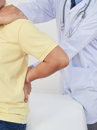 Pain management – patient with back pain receiving care from a doctor at Cranbourne West Medical Centre.