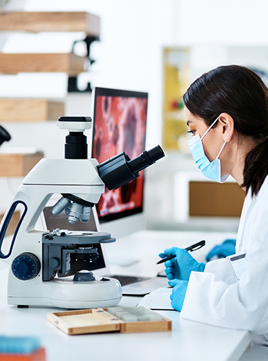 Pathology – technician analysing samples under a microscope in the on-site laboratory at Cranbourne West Medical Centre.